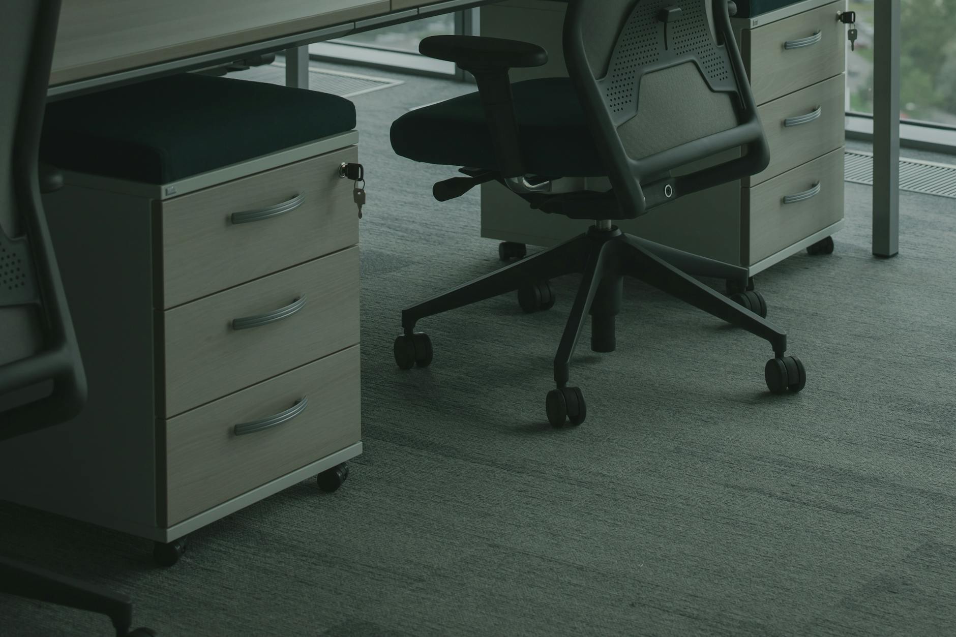 Ergonomiczne krzesła biurowe przy biurkach w jasnym, nowoczesnym biurze