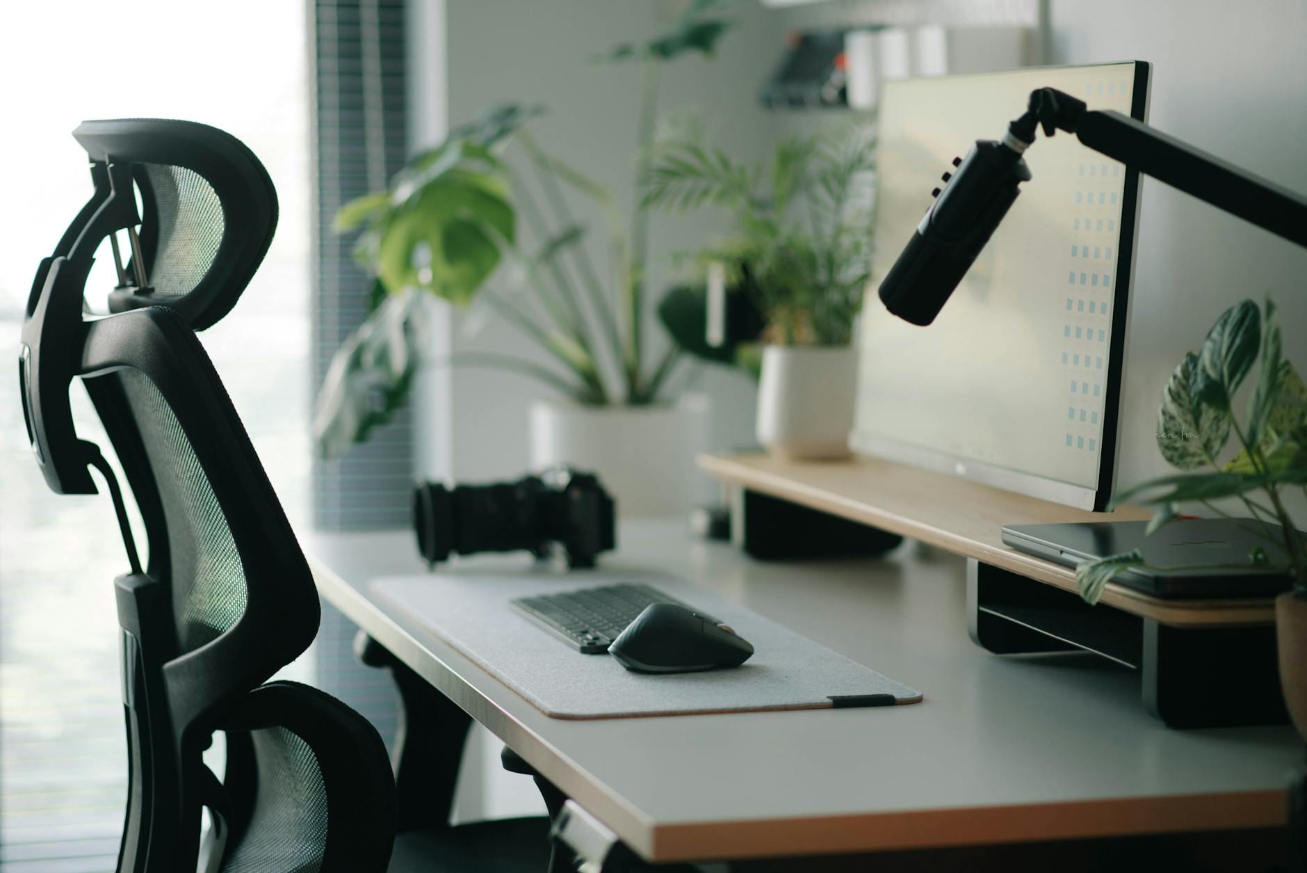 Ergonomiczne krzesło przy biurku w nowoczesnym domowym biurze z roślinami