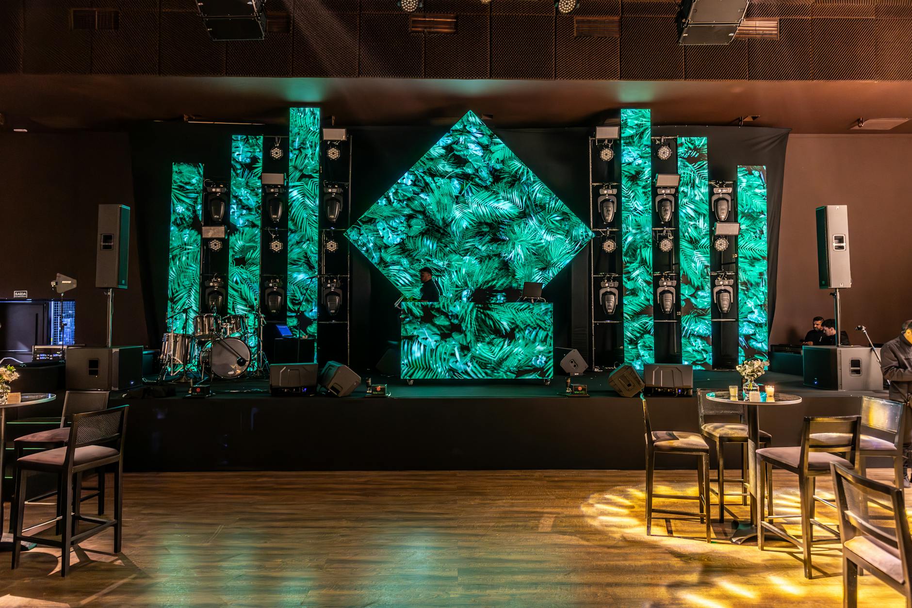 Nowoczesne stanowisko DJ-a z zielonymi panelami LED w sali eventowej