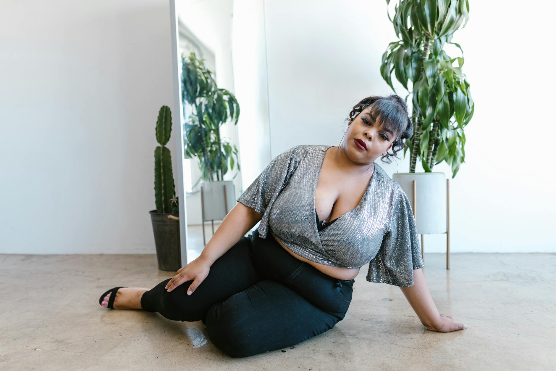 Pewna siebie modelka plus size w modnej stylizacji we wnętrzu