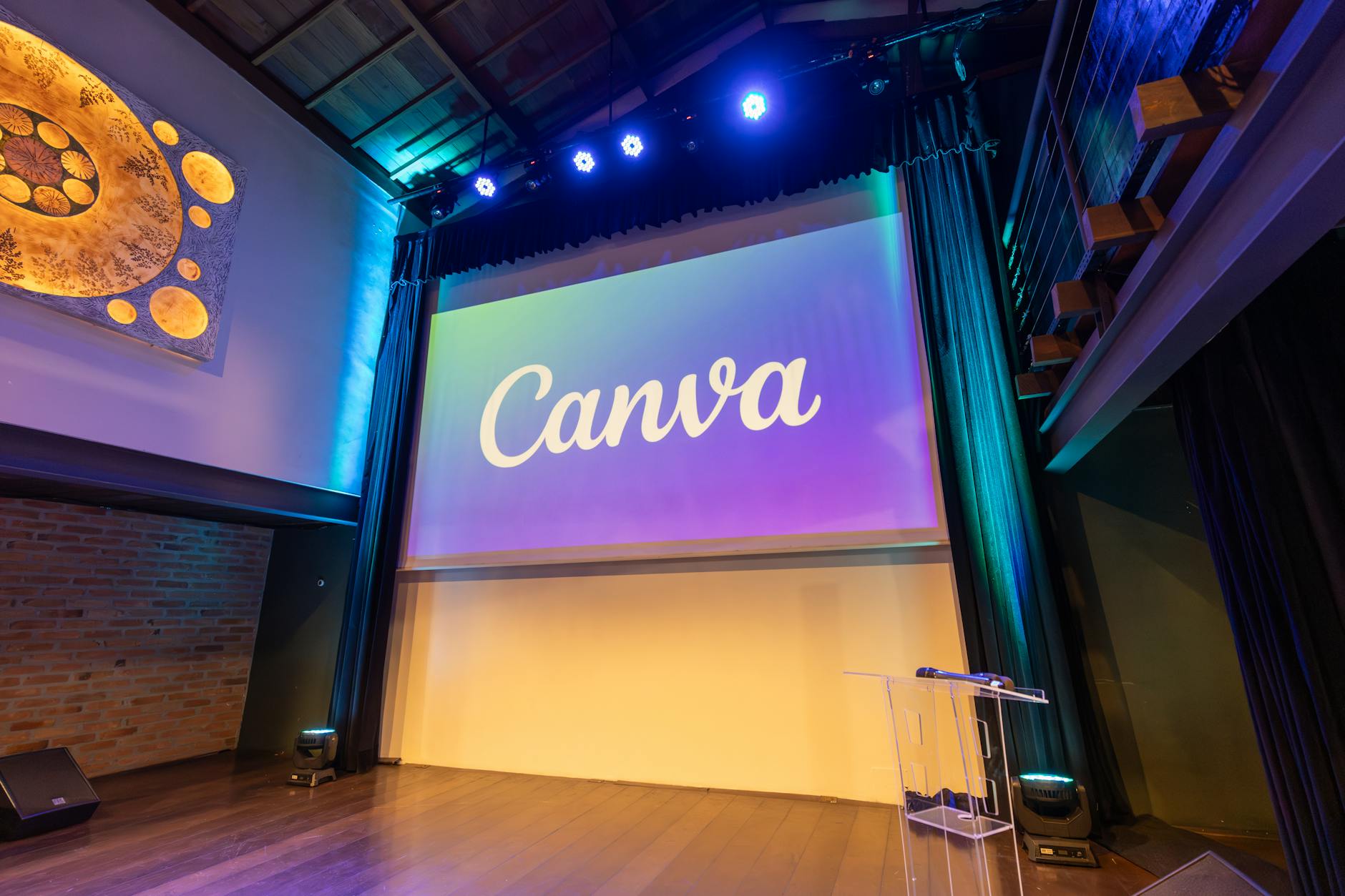 Scena eventowa z dużym ekranem i logo Canva przed prezentacją