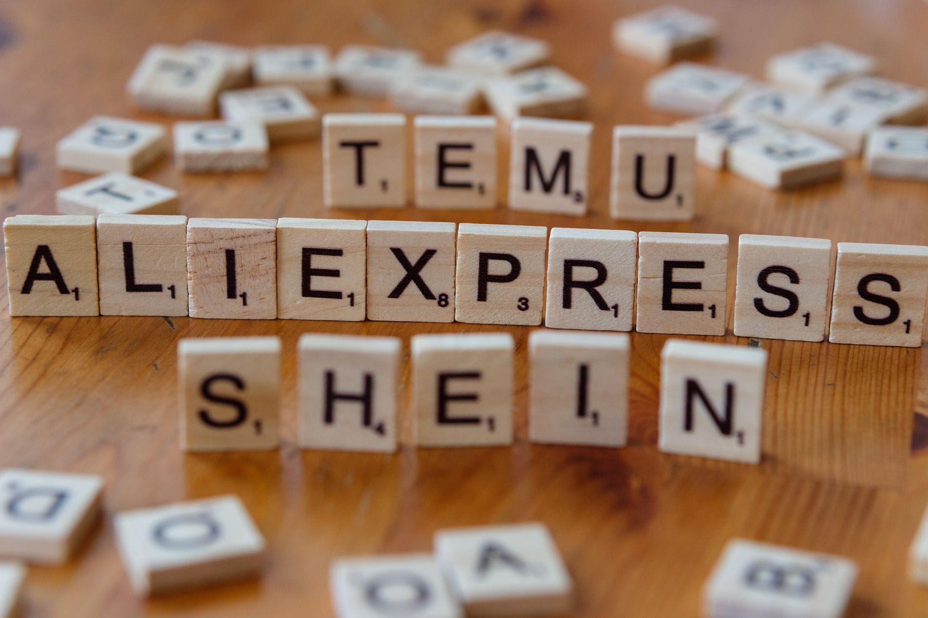 Drewniane płytki Scrabble układające nazwy platform e-commerce