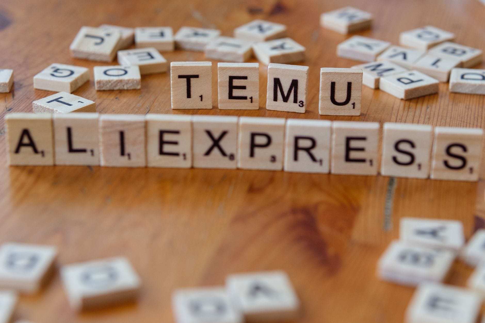 Jak taniej kupować gry komputerowe w 2024 roku: sprawdzone sposoby na promocje i okazje cenowe Klocki Scrabble z napisami TEMU i AliExpress na drewnianym stole
