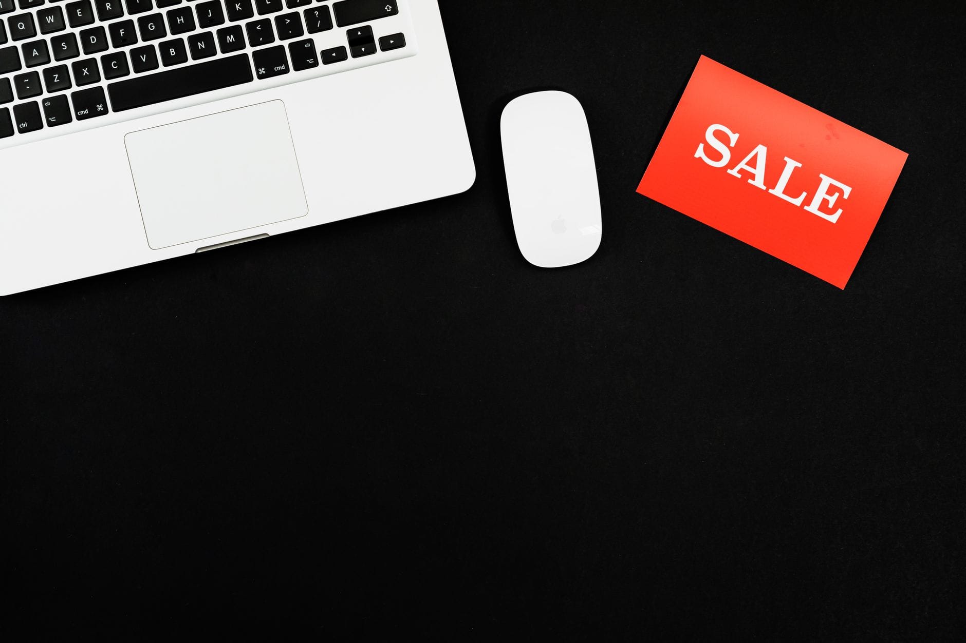 Laptop, myszka i czerwony napis sale na czarnym tle