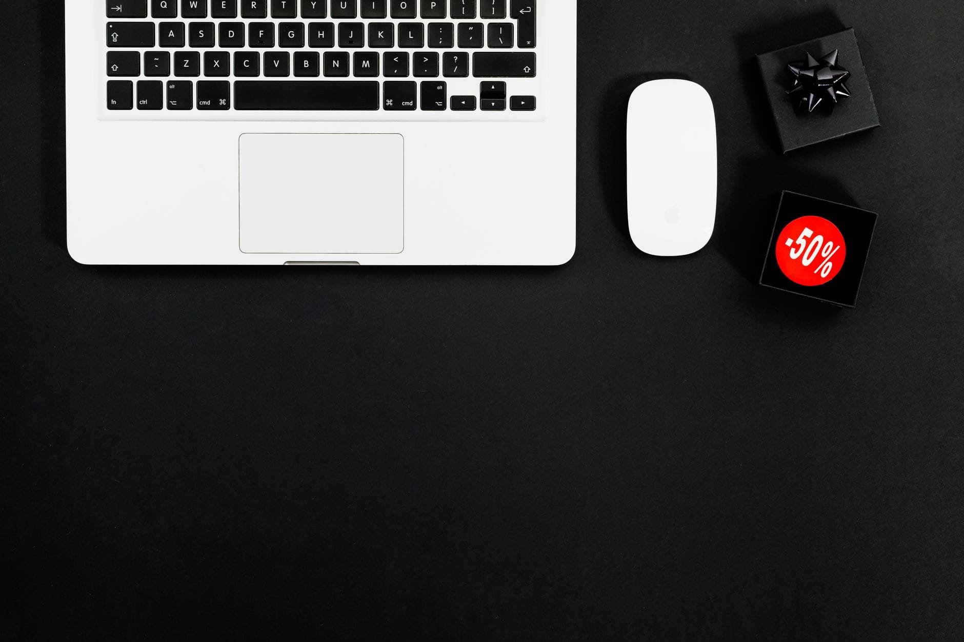 Laptop obok przedmiotów z etykietami wyprzedaży -50%