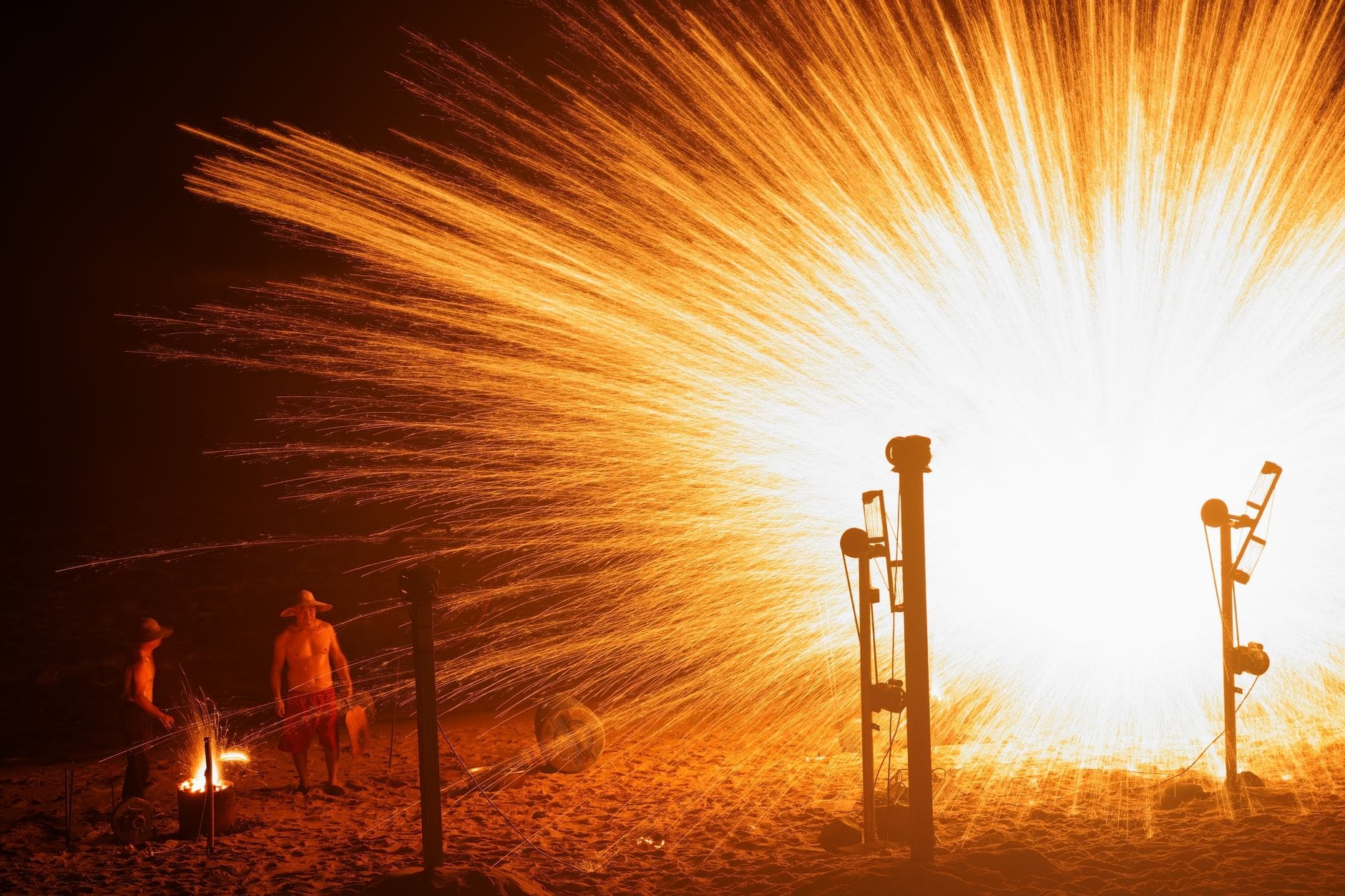 Mężczyźni oglądają nocny pokaz fajerwerków na plaży