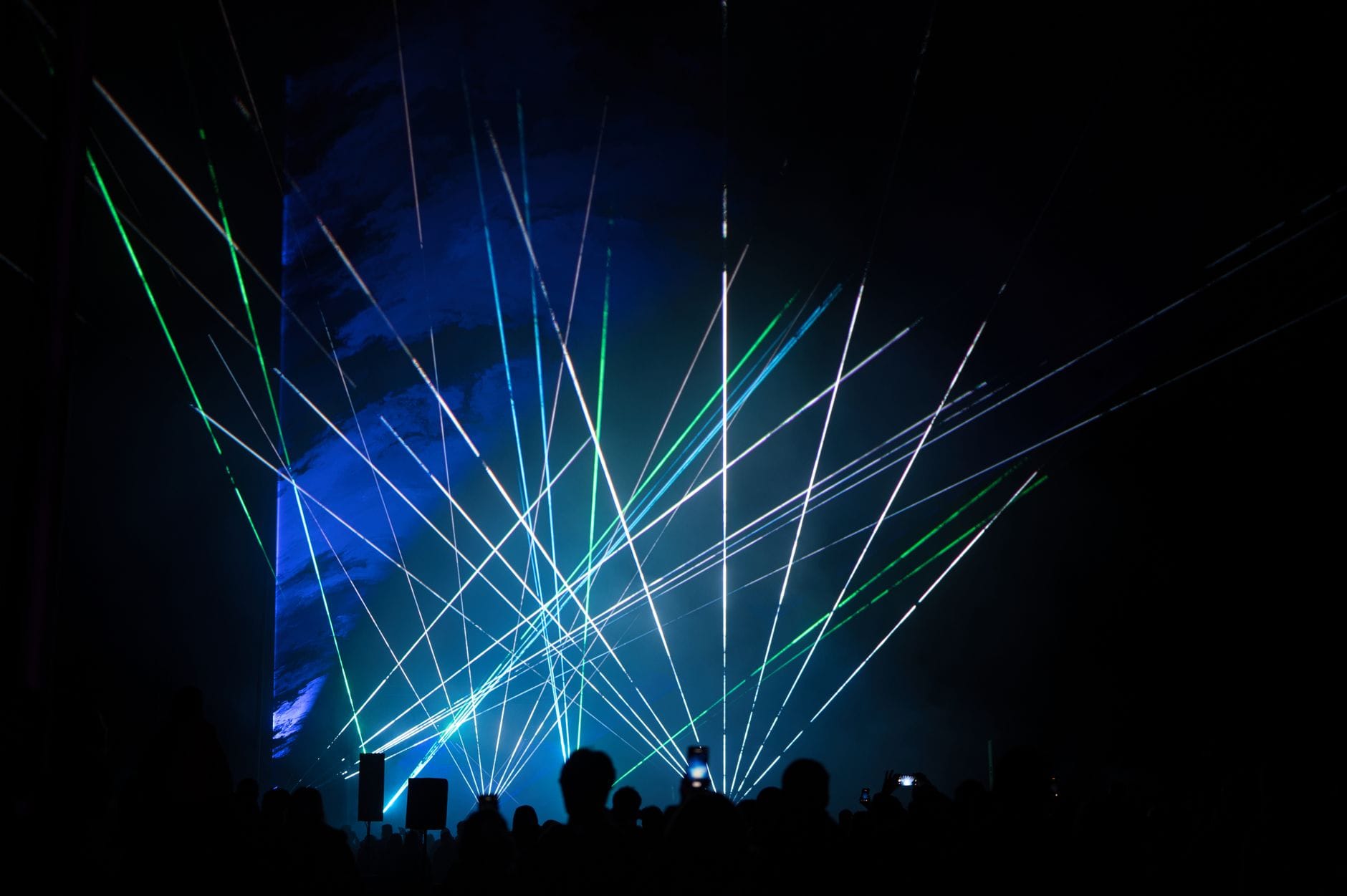 Zielono-niebieski pokaz laserowy przyciągający uwagę publiczności